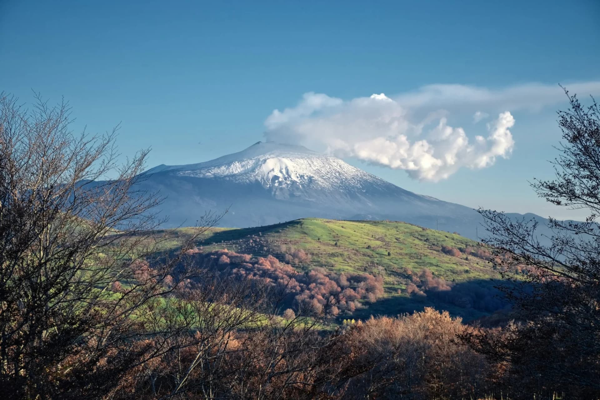 Mount Etna volcano with snow and plume viewed from Nebrodi Park, Sicily.