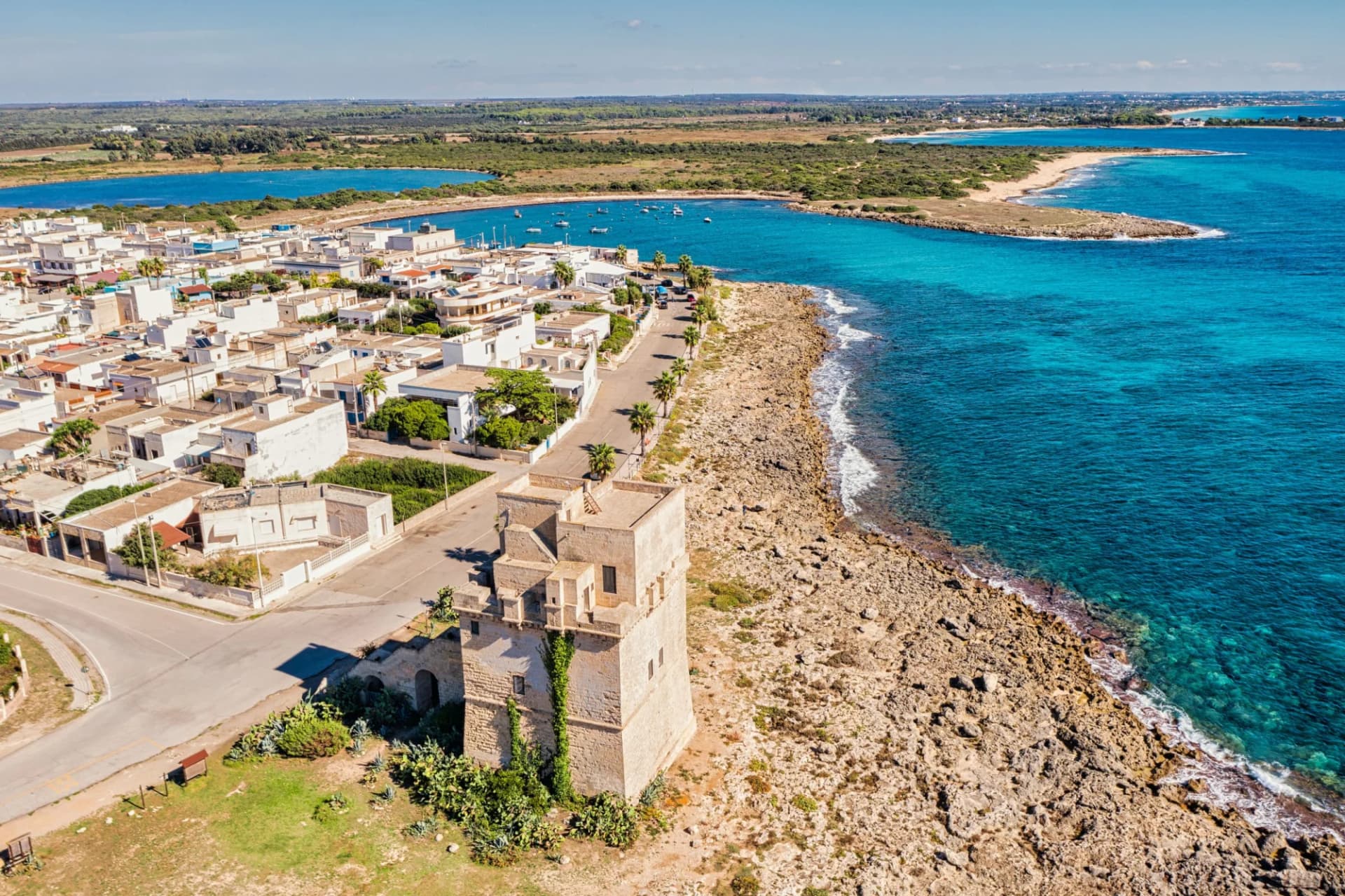 Torre Colimena in Taranto, Puglia, with white buildings and turquoise Adriatic Sea.