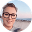 Portrait of smiling person wearing glasses outdoors with ocean in the background