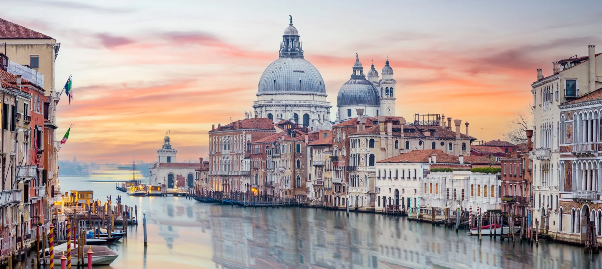 Grand Canal in Venice at sunset with Santa Maria della Salute basilica dome prominent.