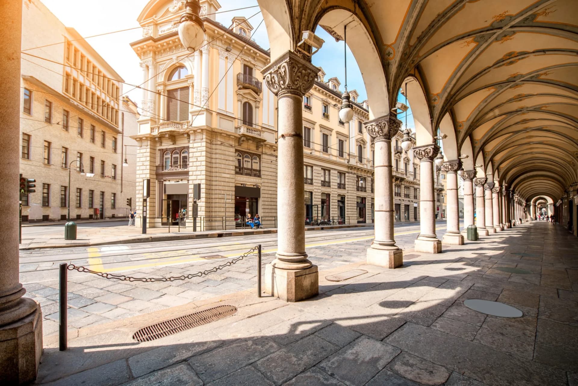 Arcaded sidewalk with ornate columns along a street in Turin, Piedmont, Italy.