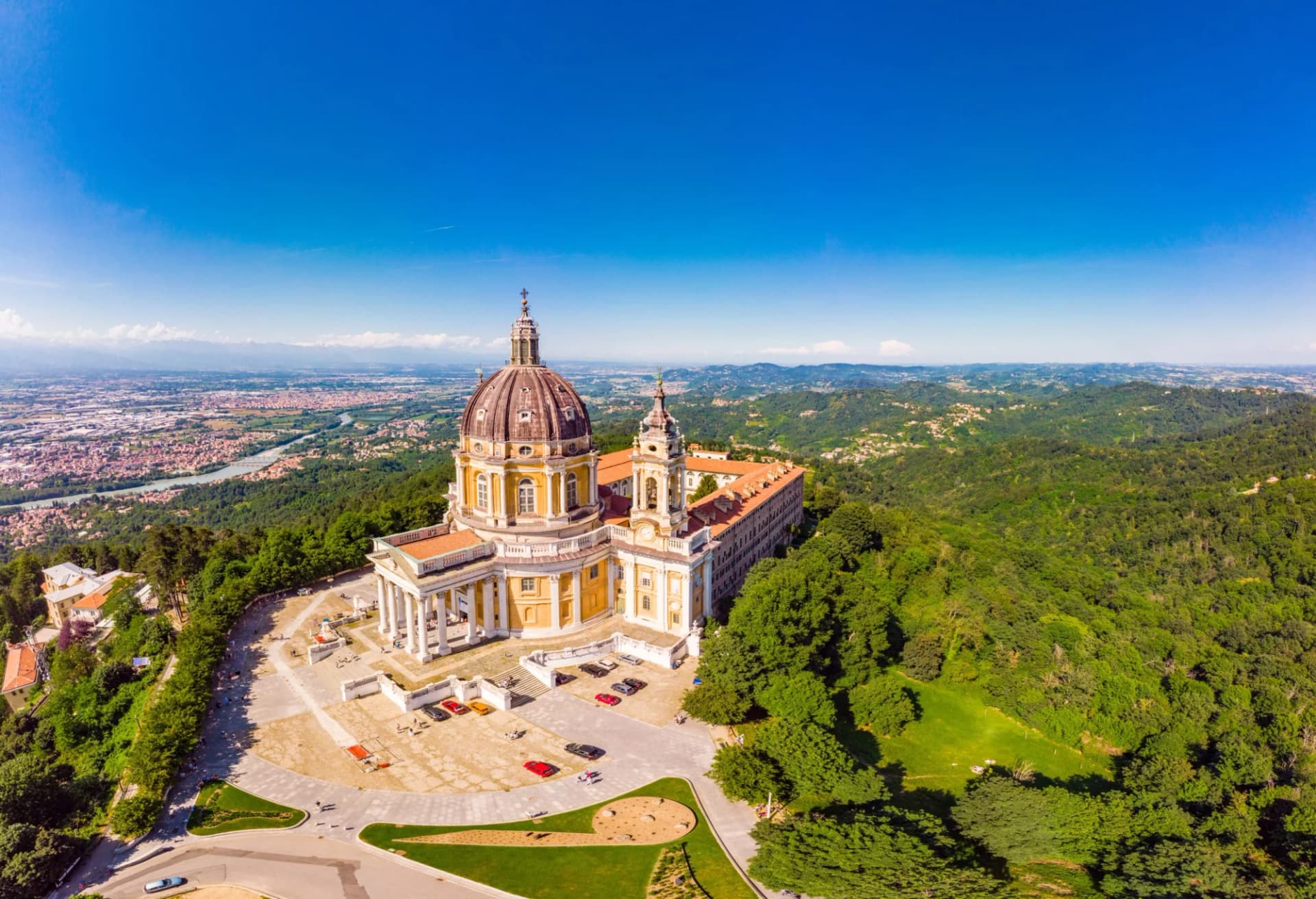 Aerial view of Basilica of Superga on a sunny summer day overlooking Turin and distant mountains.