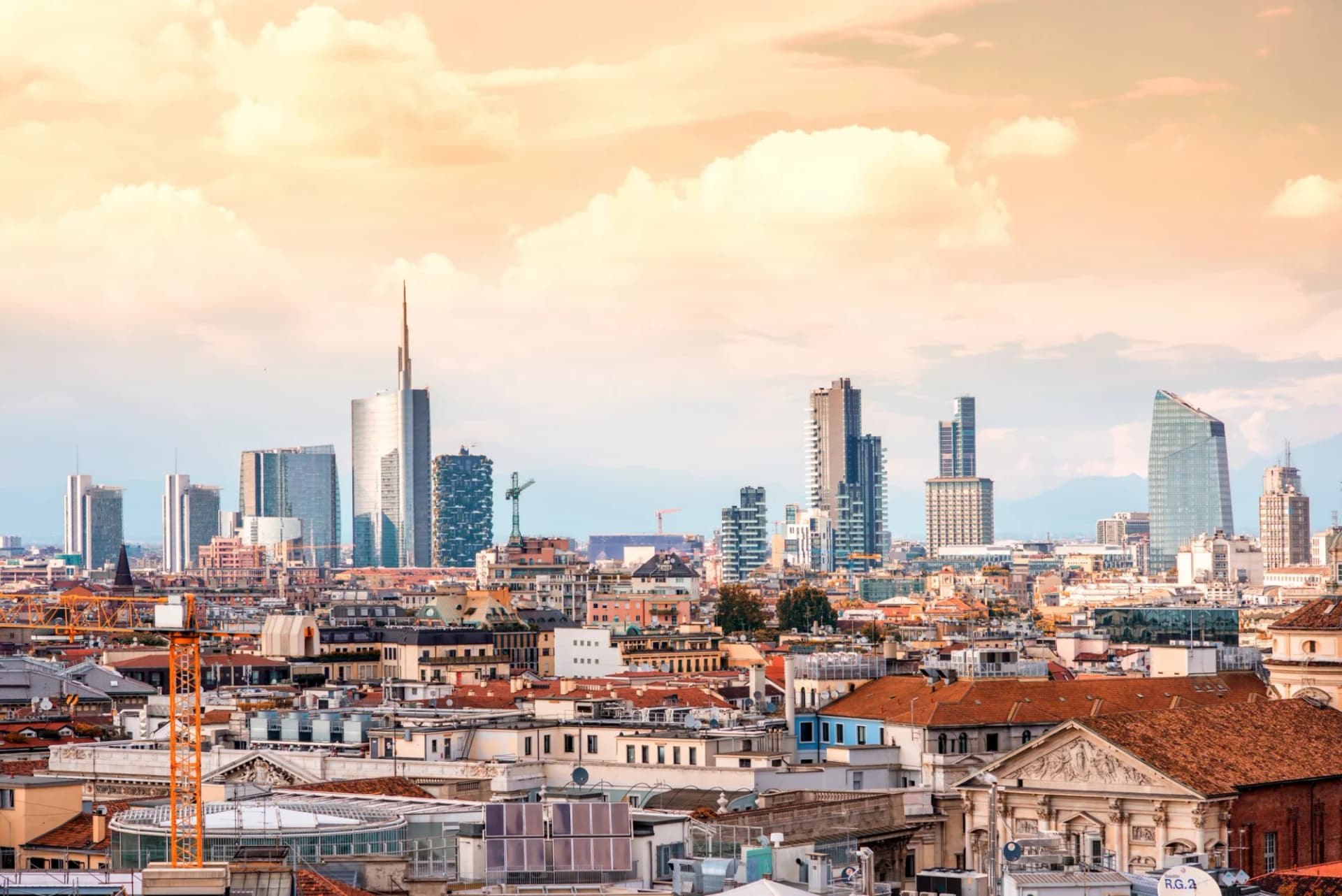 Milan skyline with modern skyscrapers in Porto Nuovo business district under a pale orange sky.