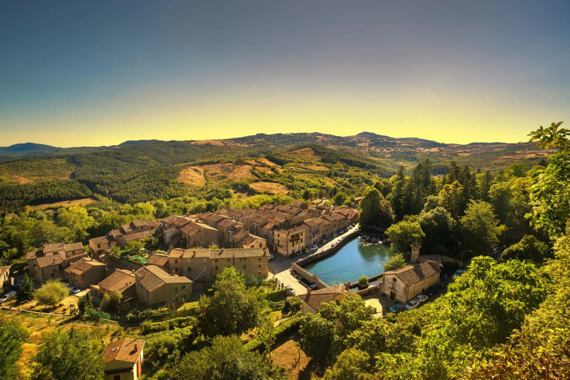 Medieval village Santa Fiora with Peschiera and church nestled in lush Tuscan hills.