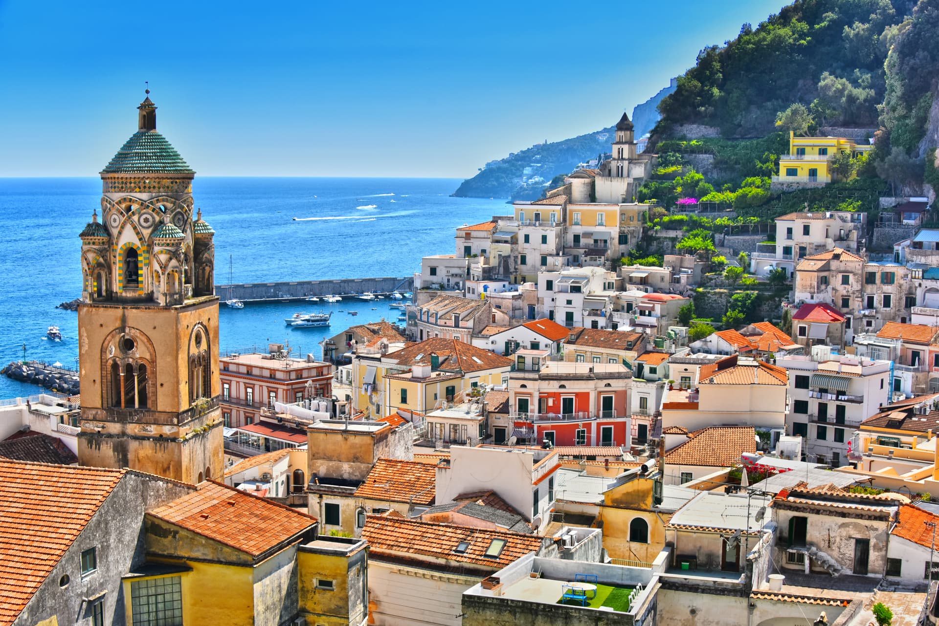 Colorful buildings climb a steep hillside overlooking the blue sea in Town of Amalfi.