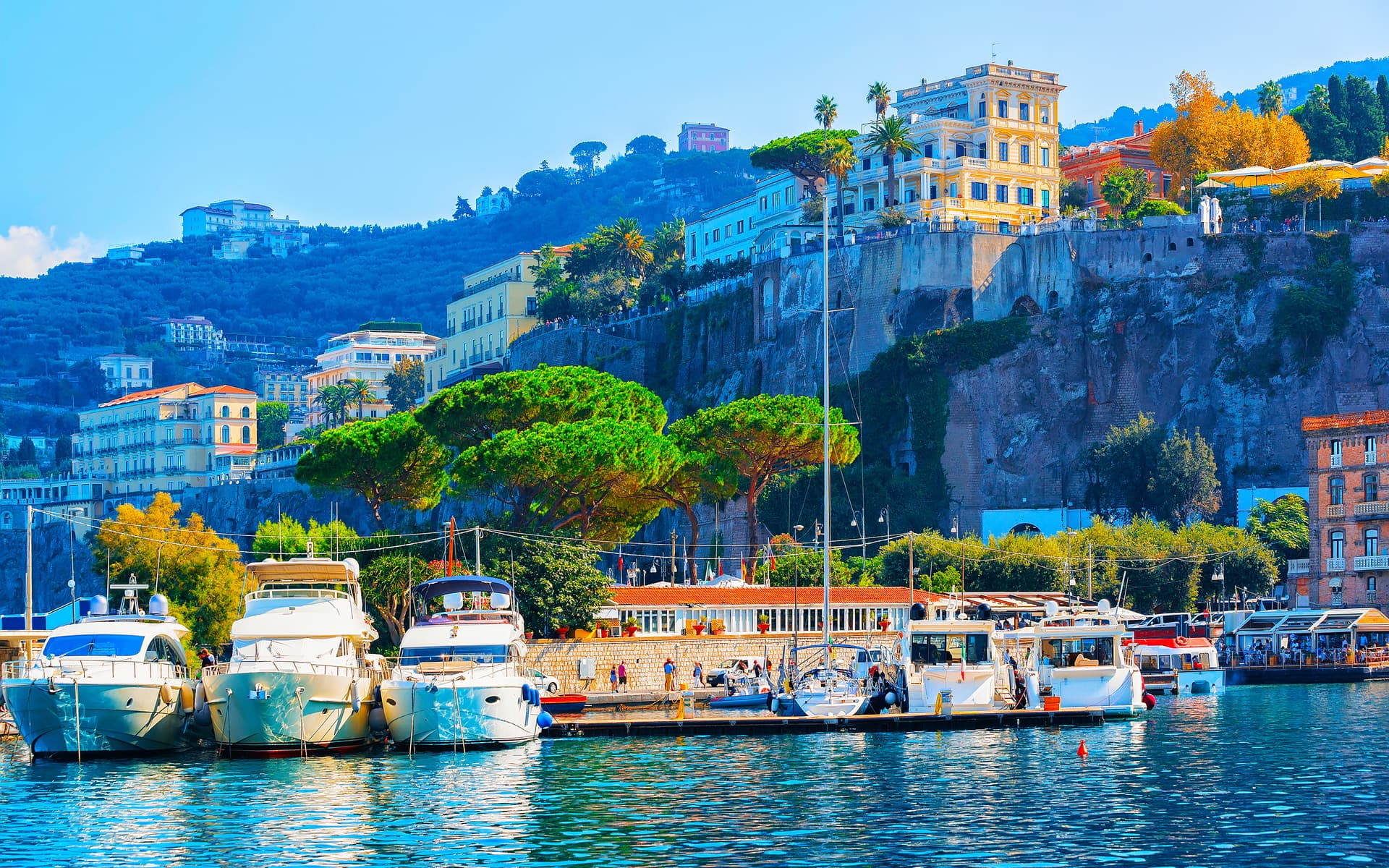 Yachts docked in harbor below cliffside buildings in Sorrento on the Amalfi Coast.