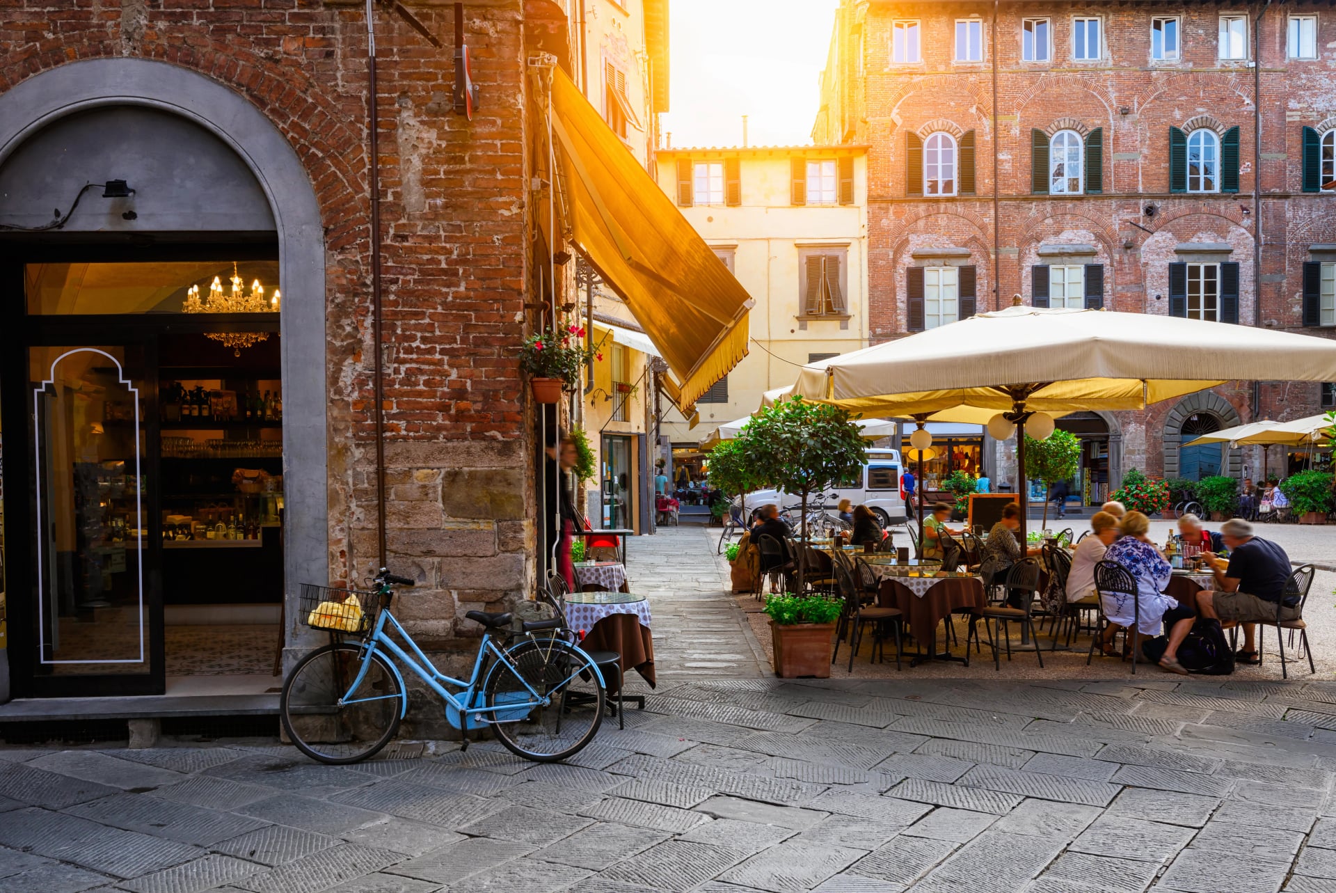 Old cozy street with tables of restaurant in Lucca, Italy