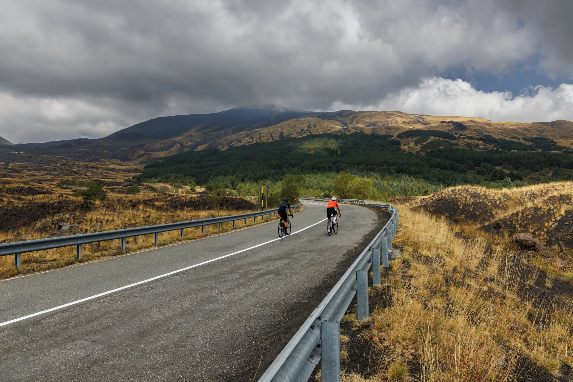 Cyclists on scenic mountain road near Mount Etna, Sicily, Italy