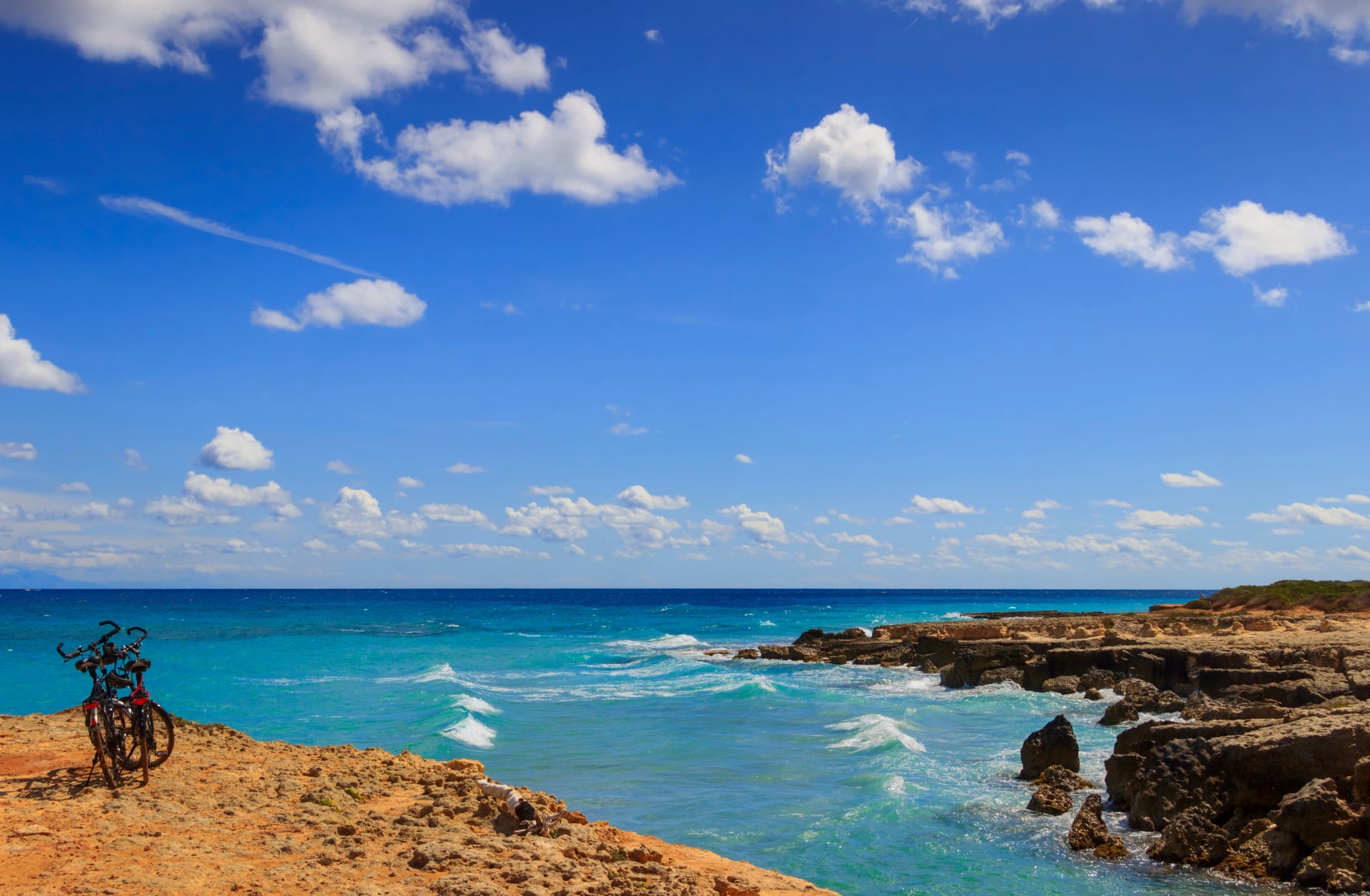 De mooiste kust van Apulië: Torre Sant' Andrea, Otranto, ITALIË (Lecce). Typische kustlijn van Salento: een paar fietsen voor excursies. Zeelandschap met kliffen, rotsachtige boog en zee-stapels.